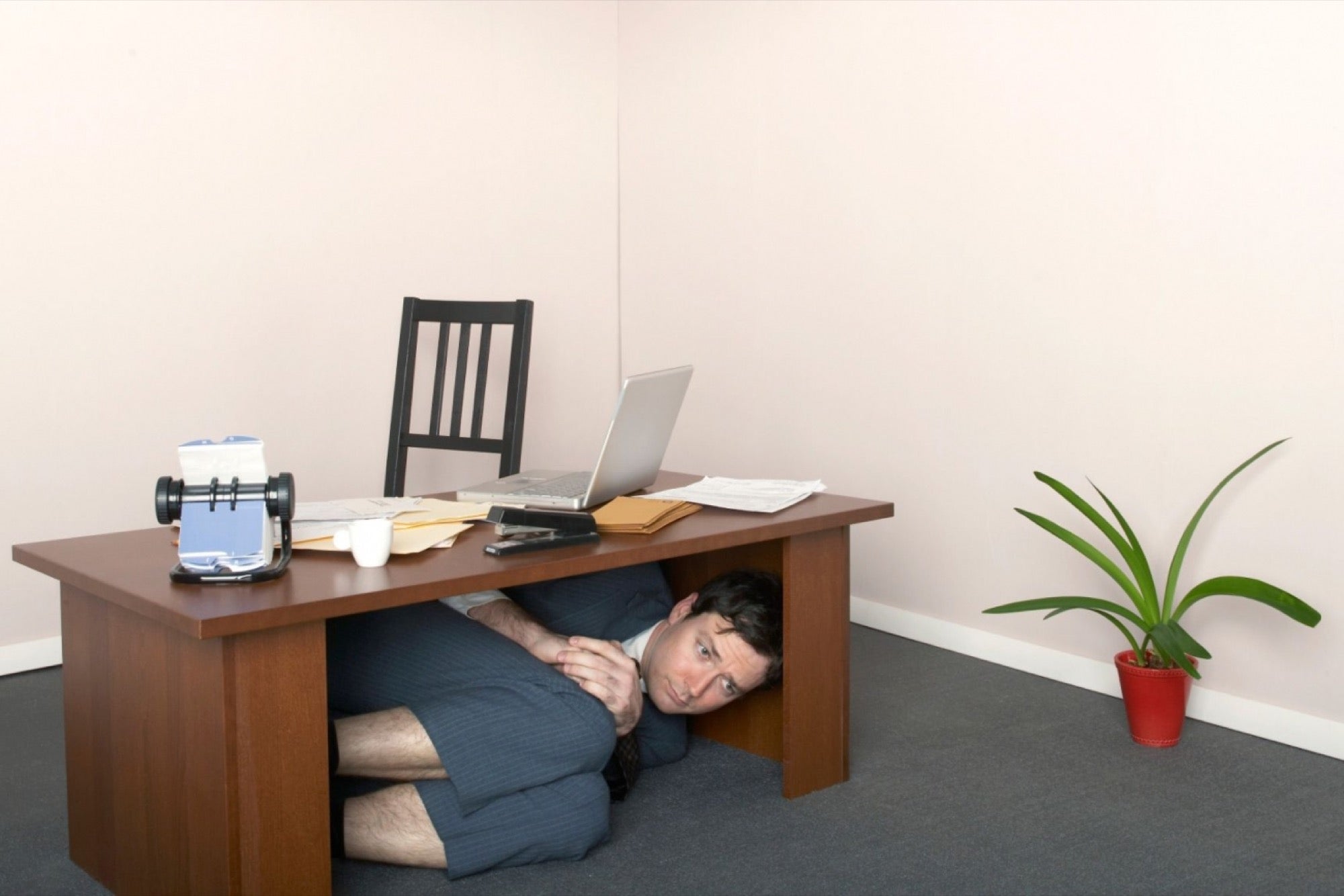 20160429181050-businessman-hiding-under-desk-table-fetal-position.jpeg