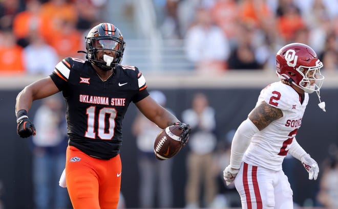 Oklahoma State's Rashod Owens (10) reacts after making a catch next to Oklahoma's Billy Bowman Jr. (2) in the second half during a Bedlam college football game between the Oklahoma State University Cowboys (OSU) and the University of Oklahoma Sooners (OU) at Boone Pickens Stadium in Stillwater, Okla., Saturday, Nov. 4, 2023.